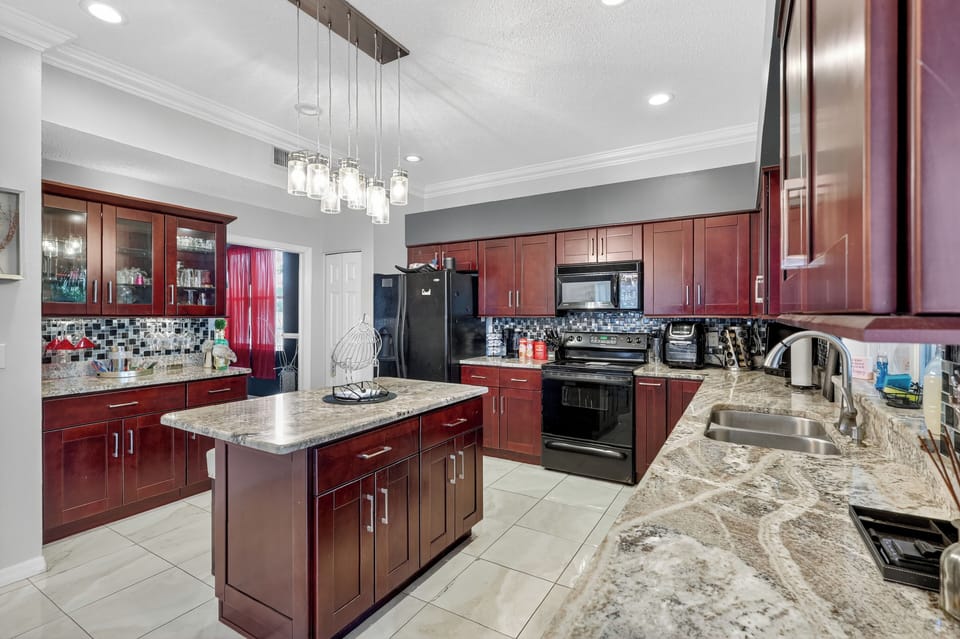 Cook meals in a bright kitchen with a large fridge.