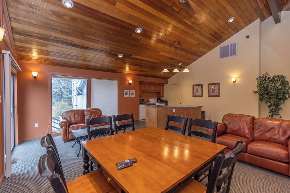 Gather around this spacious dining table under stunning wood beam ceilings, where your group can share meals and memories in comfort.