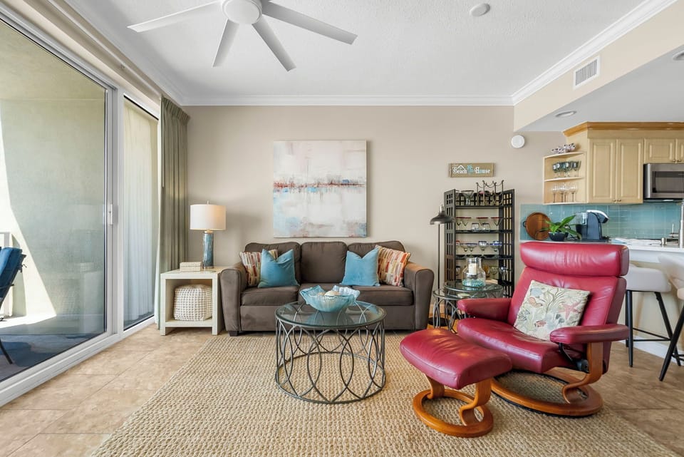 The living room offers ample, comfortable seating, a television, and breathtaking views of the gulf.