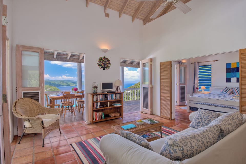 Spacious living room looking out to the dining table, deck and view beyond.