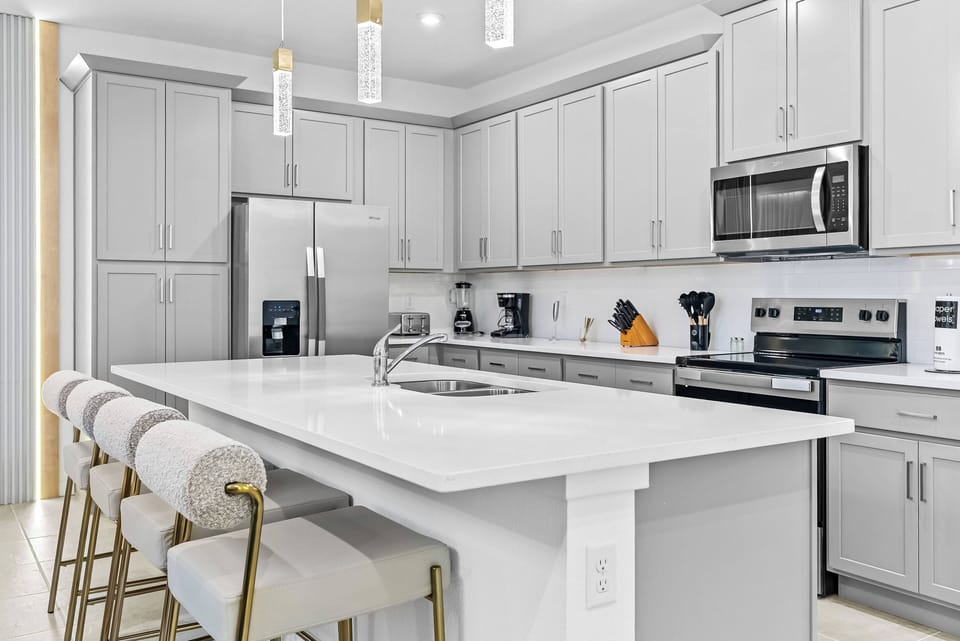 Welcome to a bright, spacious kitchen with sleek gray cabinetry and a stunning white countertop that inspires culinary creativity.