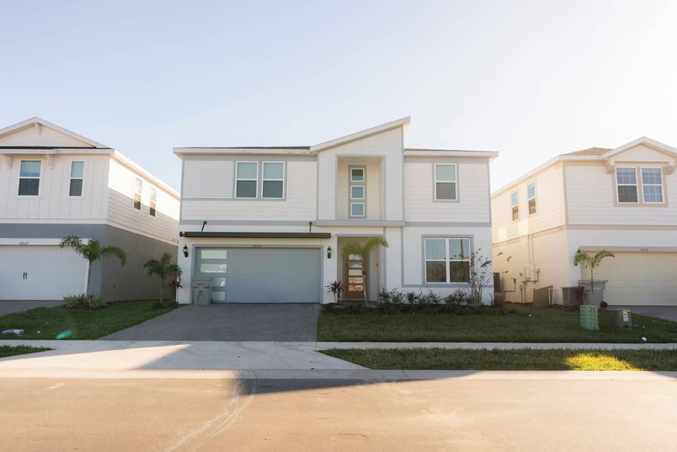 Experience a bright, airy exterior featuring contemporary architecture with clean lines and large windows. The inviting front porch and lush green landscaping create the perfect setting for a relaxing stay in this charming home.