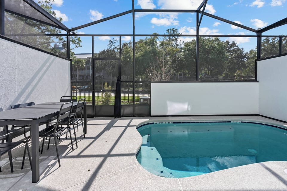 Welcome to your private oasis with a sparkling pool, stylish tile flooring, and modern furnishings. Enjoy sunny afternoons and peaceful evenings with loved ones in this spacious, screened-in area, perfect for relaxation and fun.