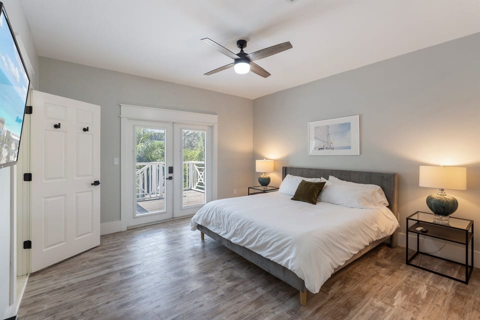 Primary bedroom with king bed. The doors lead to outdoor deck and the backyard 