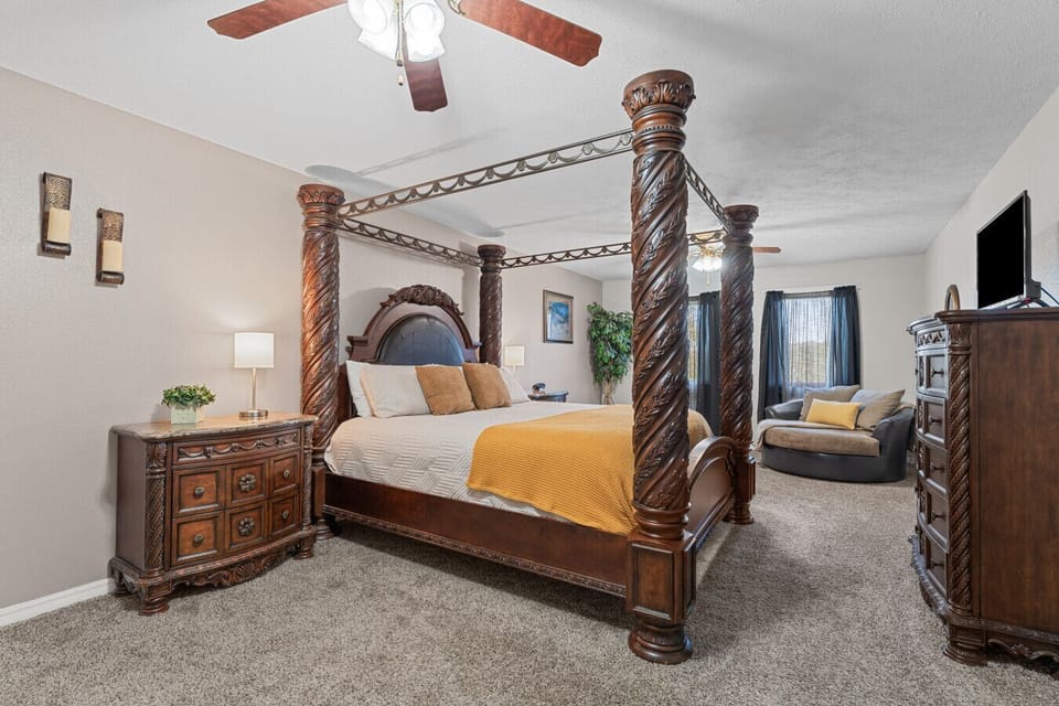 Bedroom 1 | Elegant Four-Poster Bed with Rich Wood Detailing & Cozy Seating Area