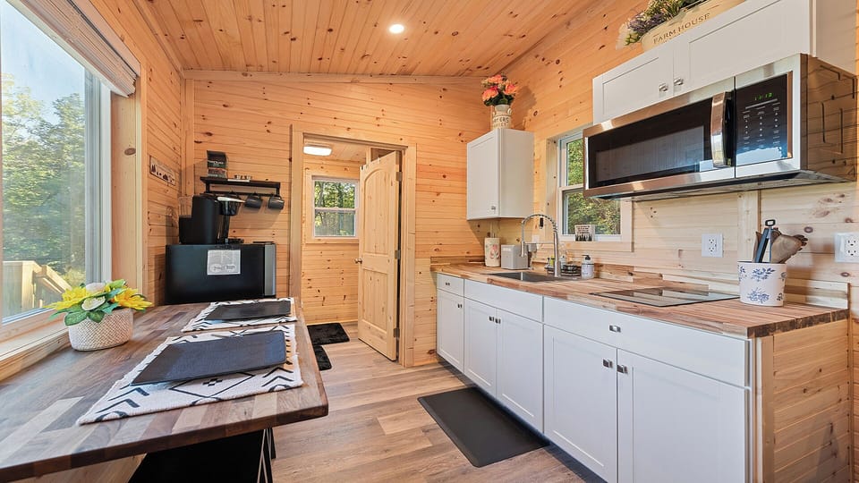 Modern kitchen with cooktop, farmhouse sink, microwave & butcher block counter