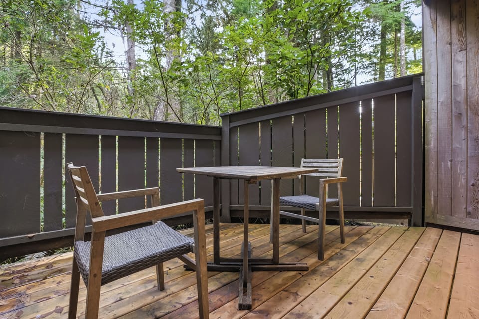 Secluded forest-view deck with bistro set, perfect for morning coffee.