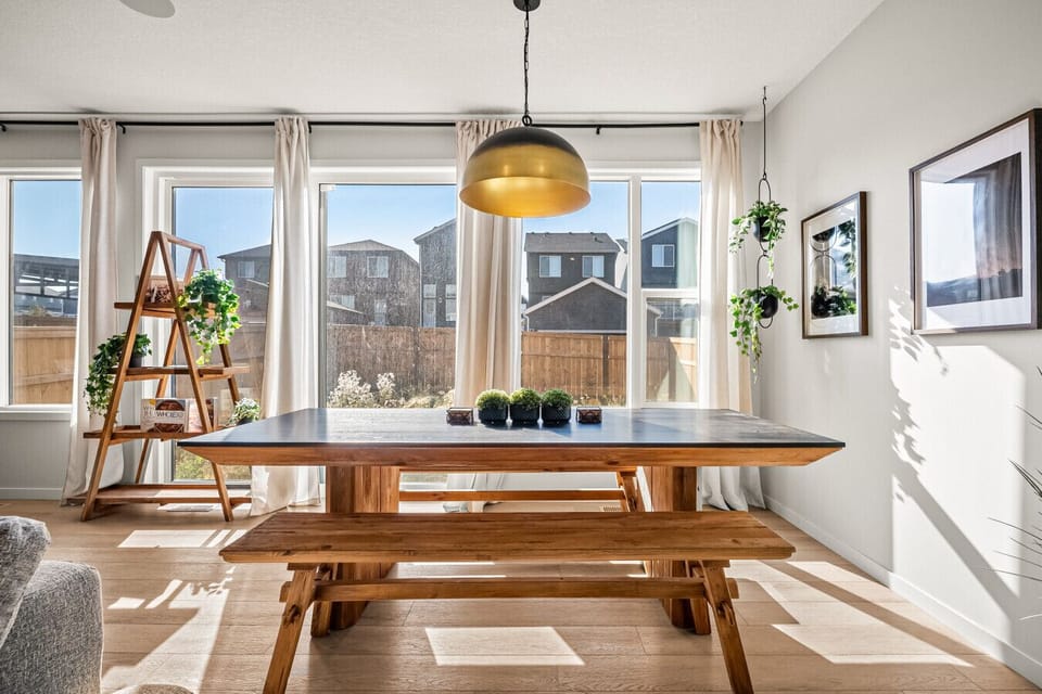 Dining room with large windows overlooking the backyard and patio