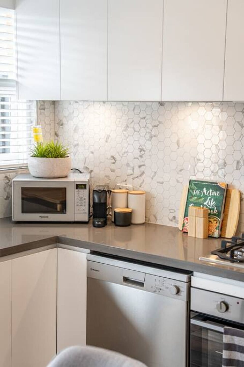 Start the morning with fresh coffee and natural light filtering through this stylish, well-equipped kitchen.