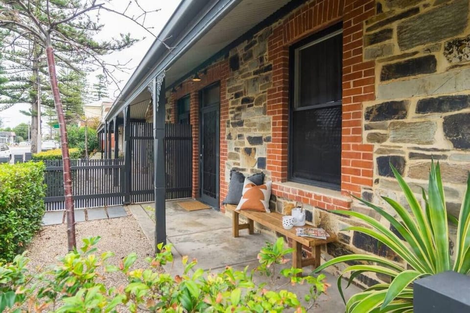 Heritage stonework, a quiet bench, and a little greenery—this front porch has charm to spare.