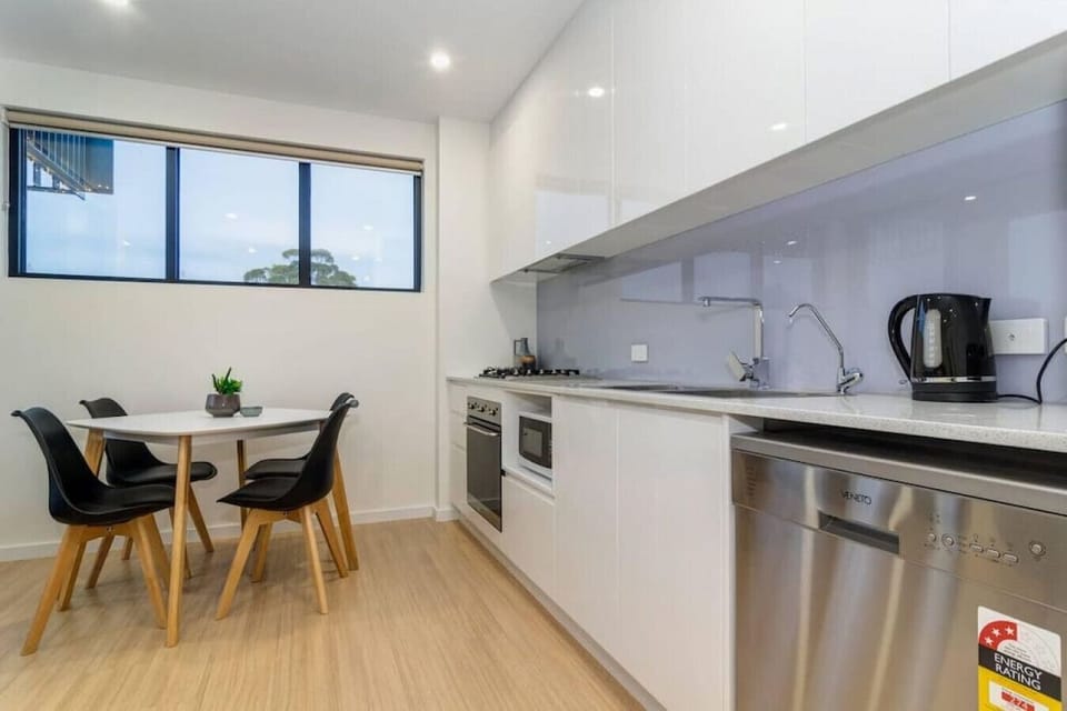 Cook meals in the streamlined kitchen with built-in appliances, glossy cabinetry, and a tucked-away dining nook.