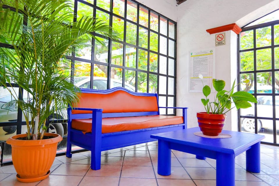 Relax on the colorful sofa beside sunlit garden views.