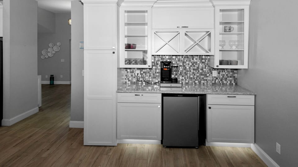 Elegant coffee bar with plenty of storage space, glass cabinets and fridge - ideal for that first coffee in the morning