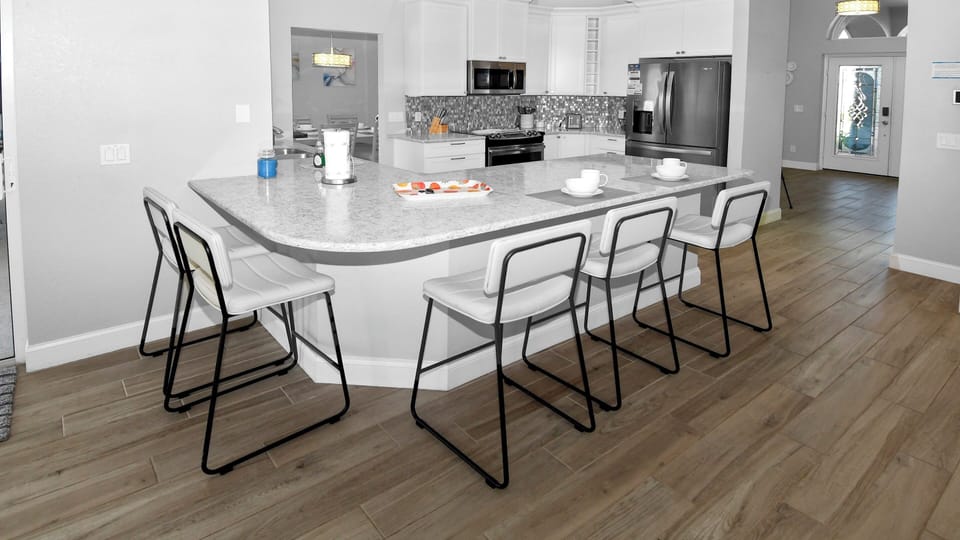Bright kitchen with large breakfast bar in modern design and high-quality appliances.