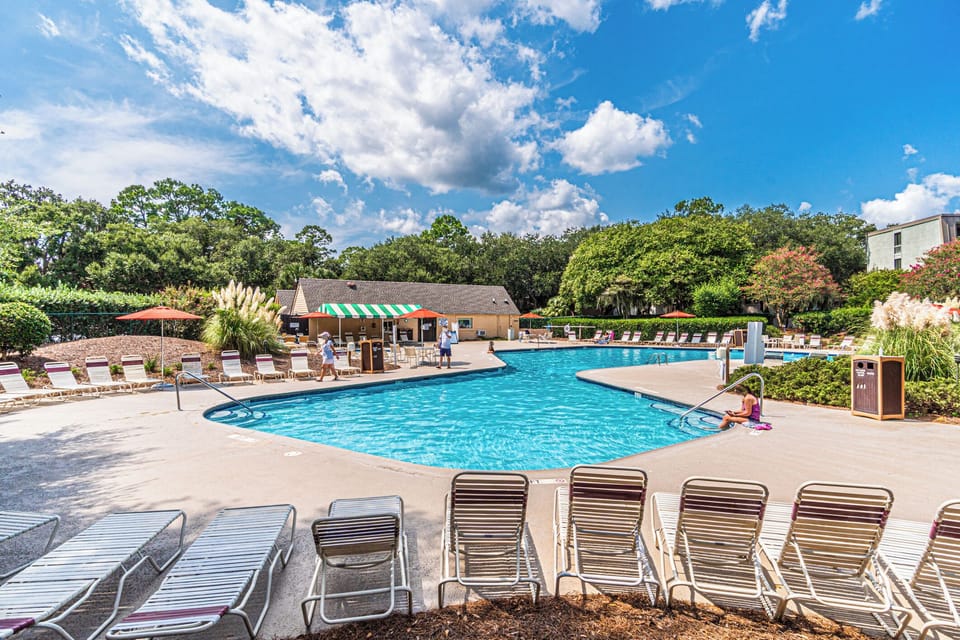 Inviting pool with lounge chairs, umbrellas, and plenty of space to relax under the sun.