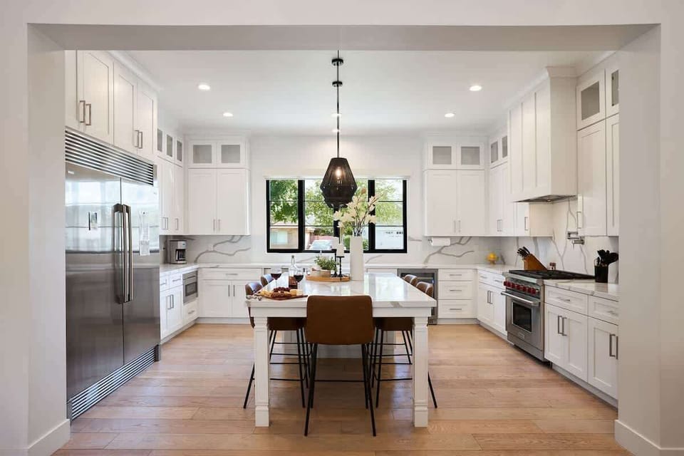 Fully equipped kitchen with stainless steal appliances, mini fridge, and a kitchen island with bar seating for 5 guests.