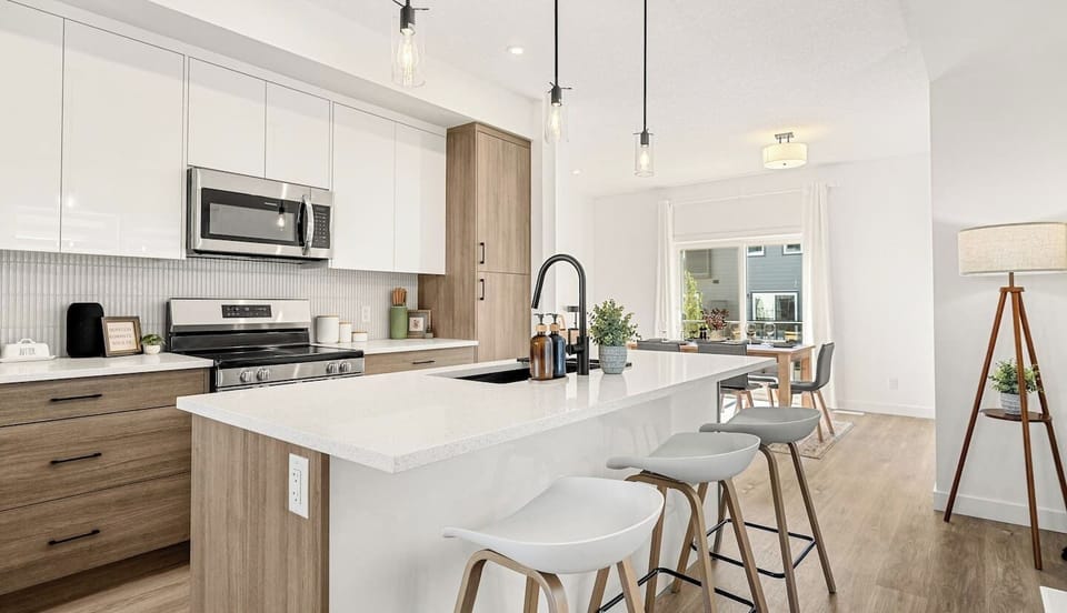 Well-equipped kitchen features white island, stainless steel appliances, and ample counter space