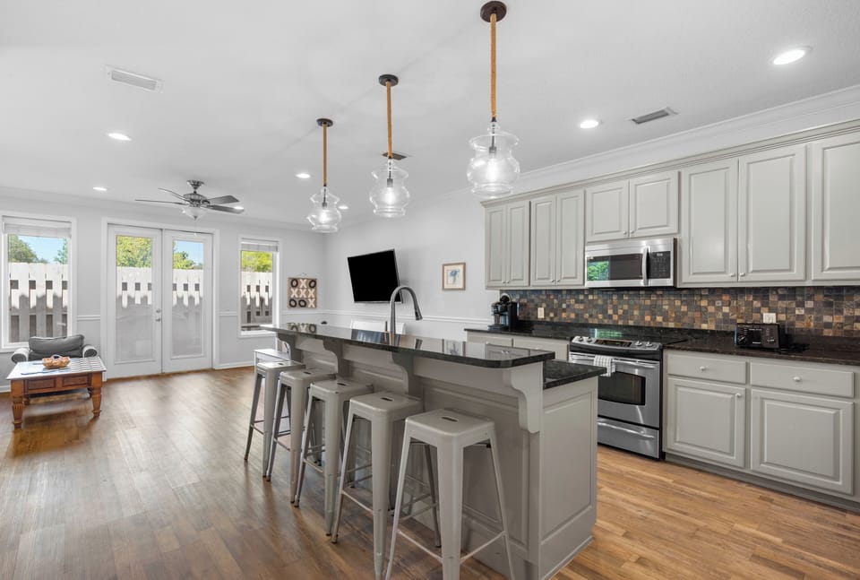 Modern kitchen with a large island and bar seating that seamlessly flows into the living area. 