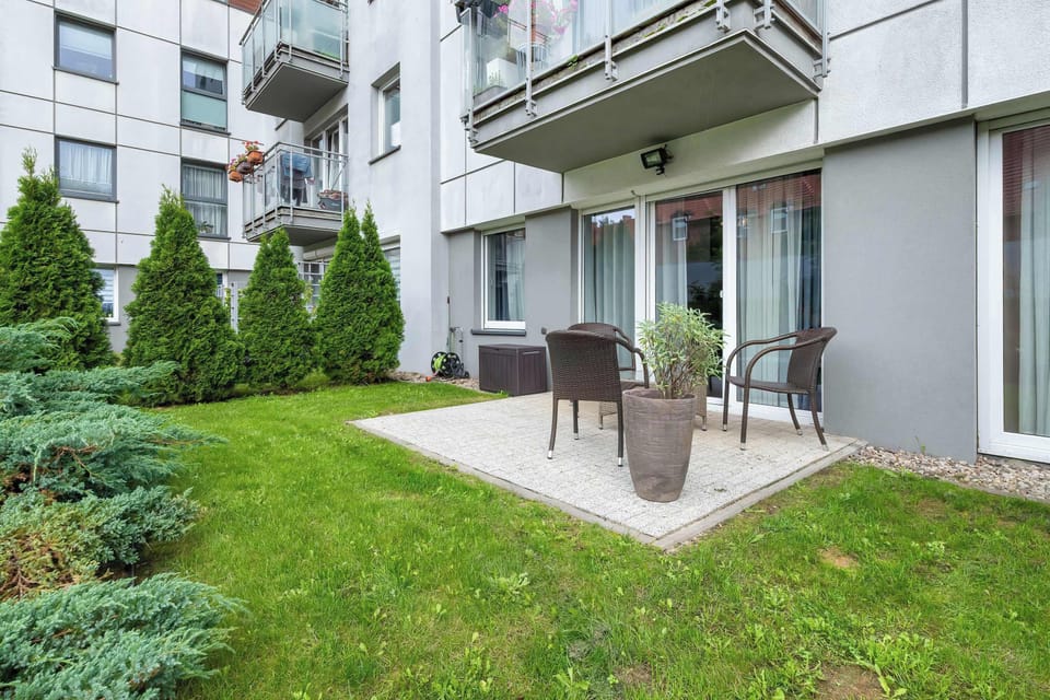 An exterior view of the building with green lawns and balconies. Outdoor space feels private and inviting.