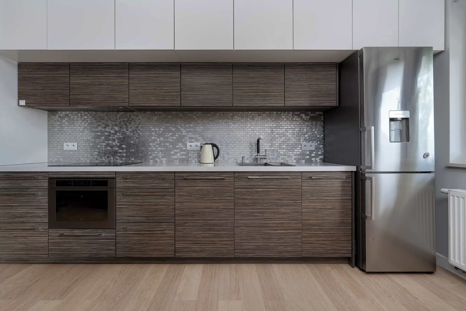 A stylish kitchen with dark cabinetry and built-in appliances. Perfect for preparing meals during your stay.