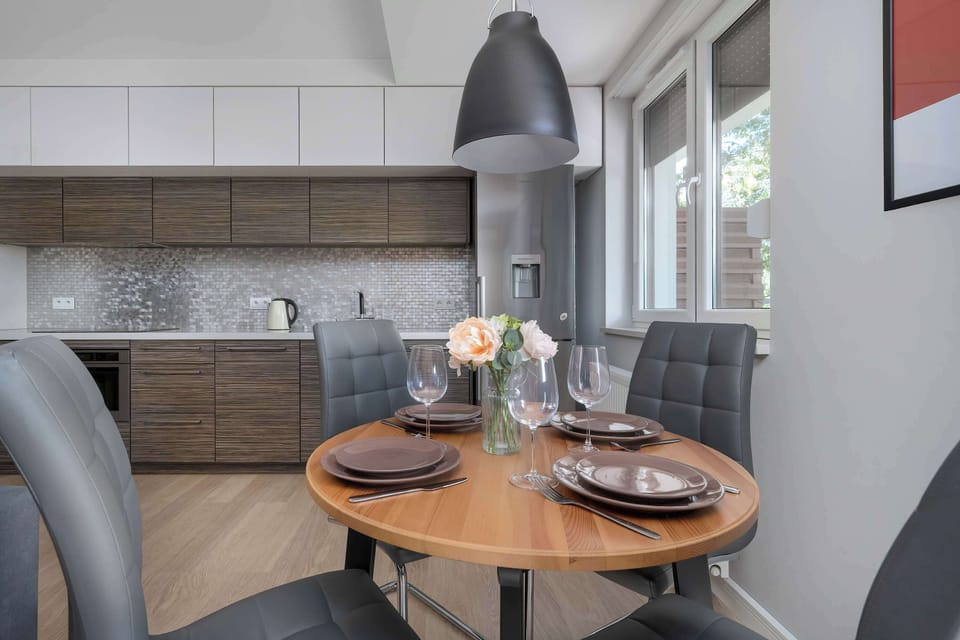 A modern dining space with a round table and gray chairs. Ideal for enjoying meals with family or friends.
