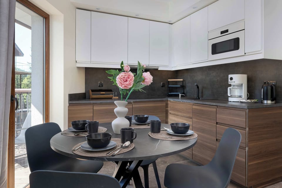 The modern kitchen with a round table and full tableware set invites you to enjoy shared meals in a homely atmosphere.