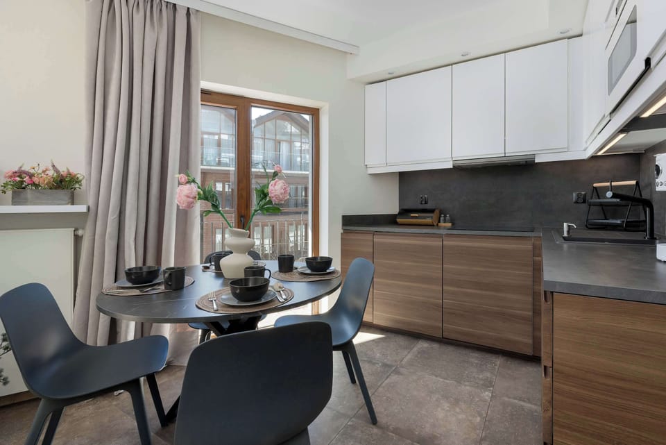 The dining area with a round table by a large window offers a bright space perfect for shared meals.