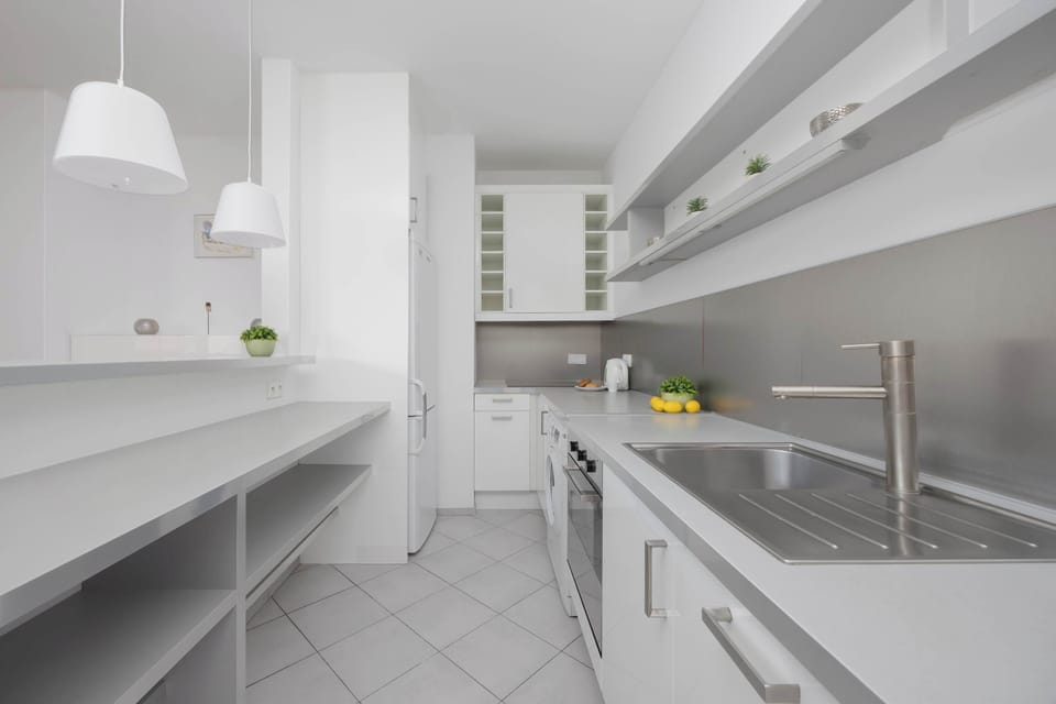 A bright kitchen with white cabinets and plenty of counter space. Modern appliances make it fully equipped for longer stays.