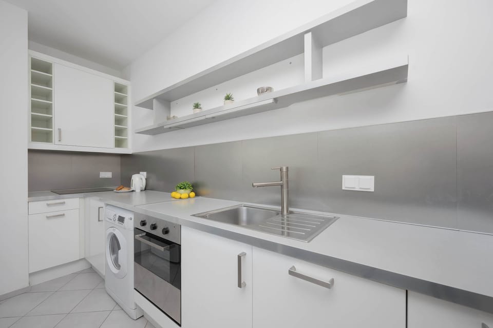 A different angle of the kitchen showing the sink and stovetop area. The design is sleek and practical for everyday use.