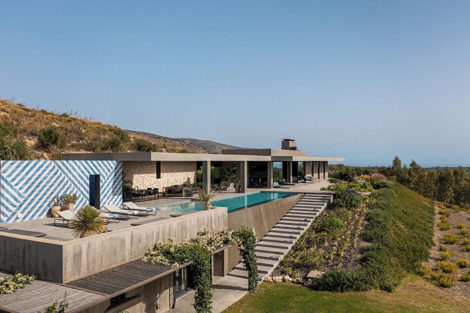 Steps lead down below the pool's infinity edge to the accommodation on the lower level.
