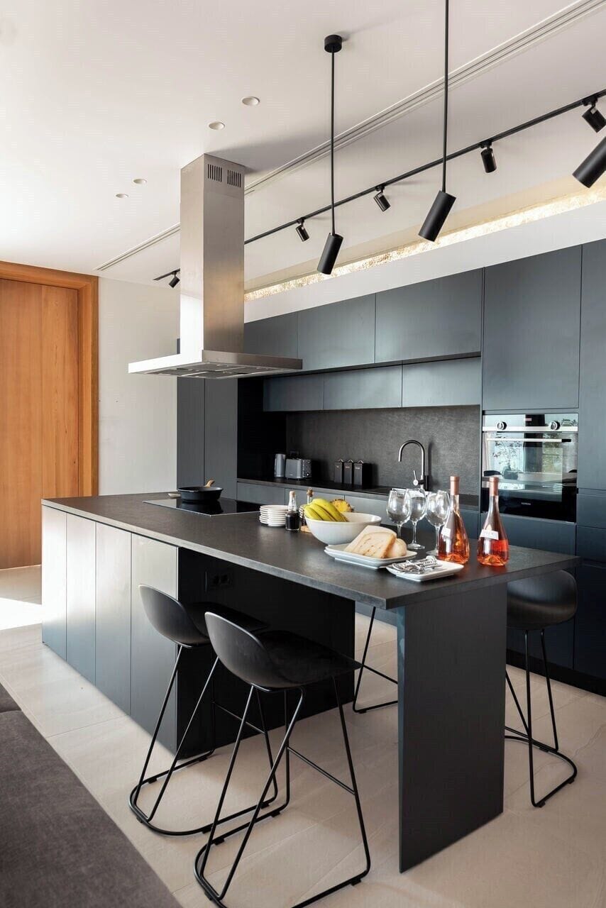 The sleek, well-equipped contemporary kitchen runs behind the living and dining areas.