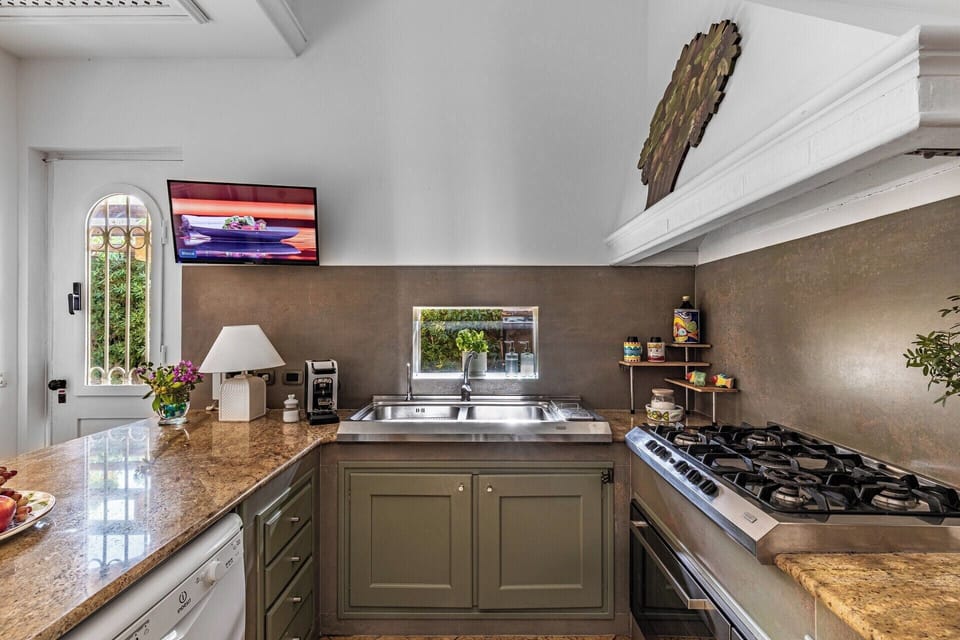 The well-equipped kitchen has access to the gardens.