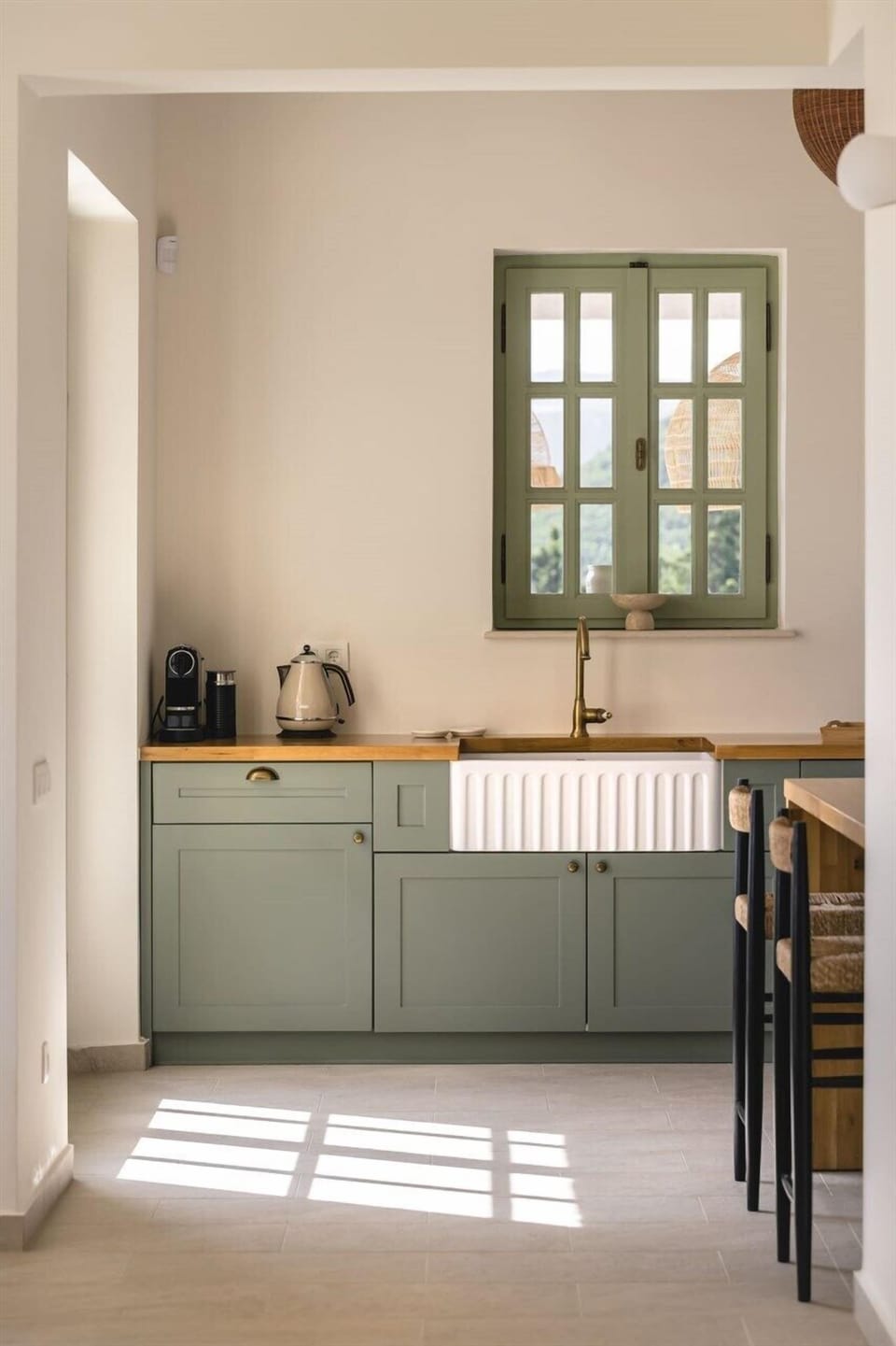 The tranquil, olive-coloured cabinetry and breakfast bar.