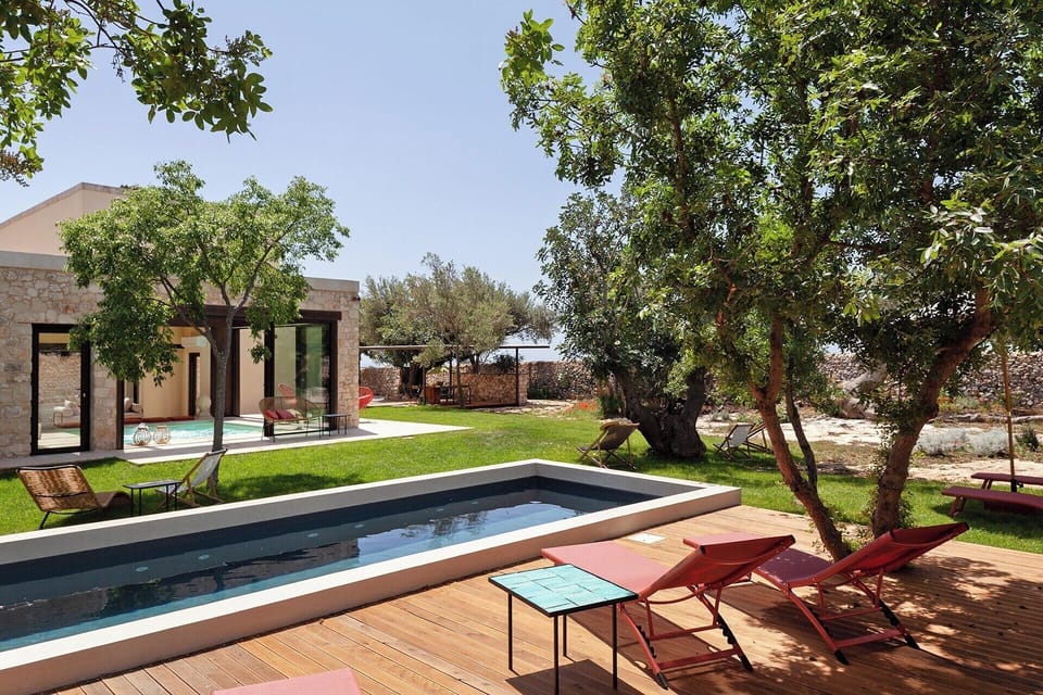 The house and gardens seen from by the pool.