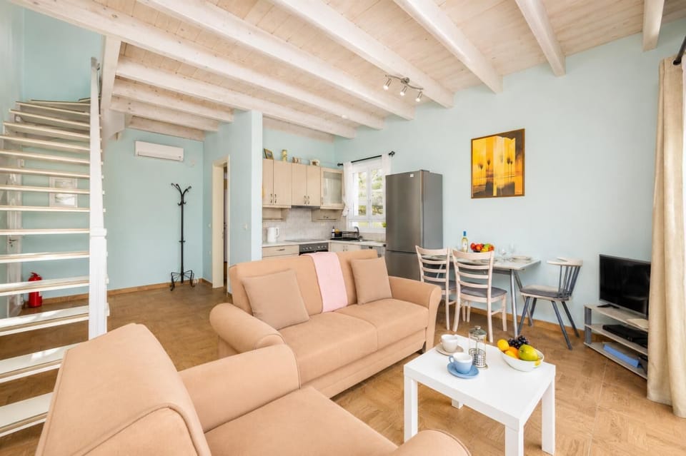 Open-plan living room with sofas, dining area, kitchen, A/C, WiFi internet, satellite TV, and sea views