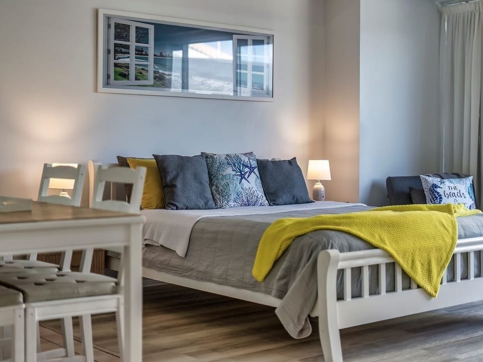 Studio layout includes queen bed, TV, sofa bed option and dining table close by.
