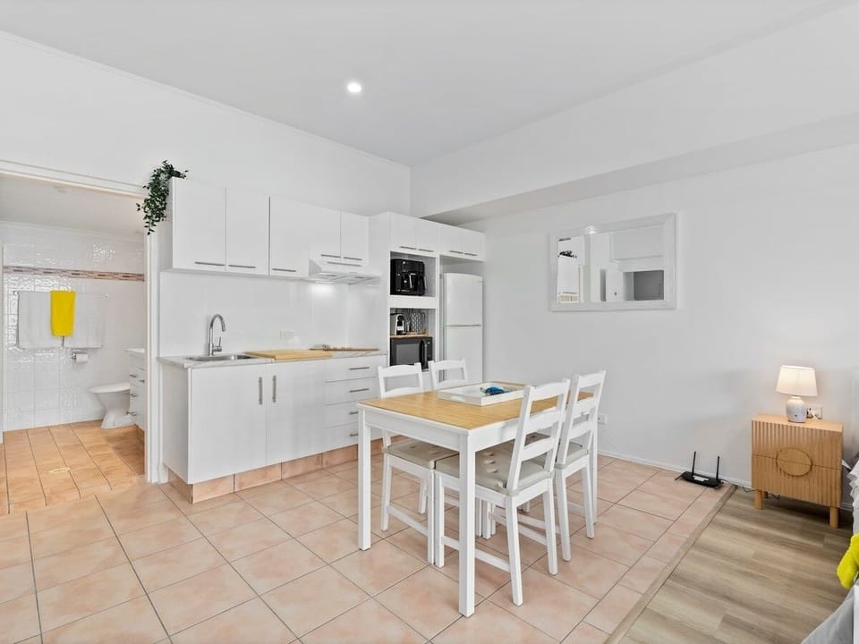 Kitchen and dining sit together with appliances and a table seating four guests.