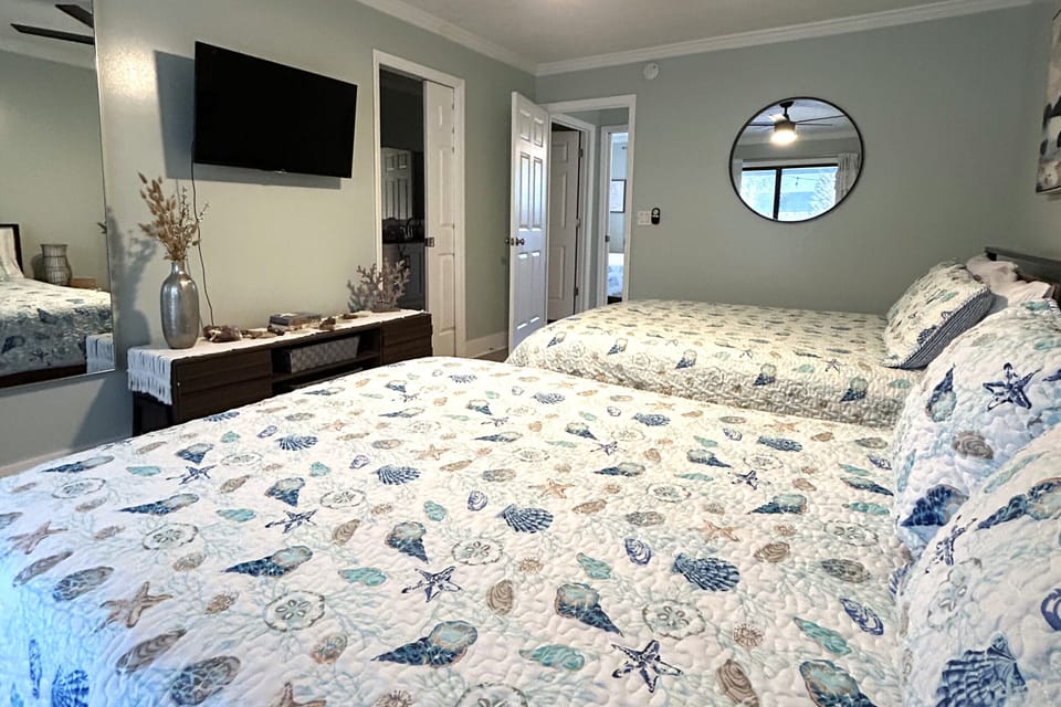 Coconut Cove's second-level bedroom with 2 queens, a closet, TV, and balcony