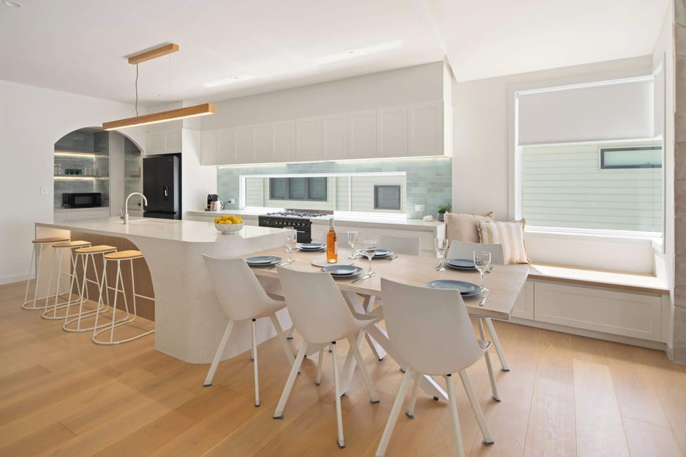 Elegant dining space with a large table, cozy bench seating, and minimalist décor.