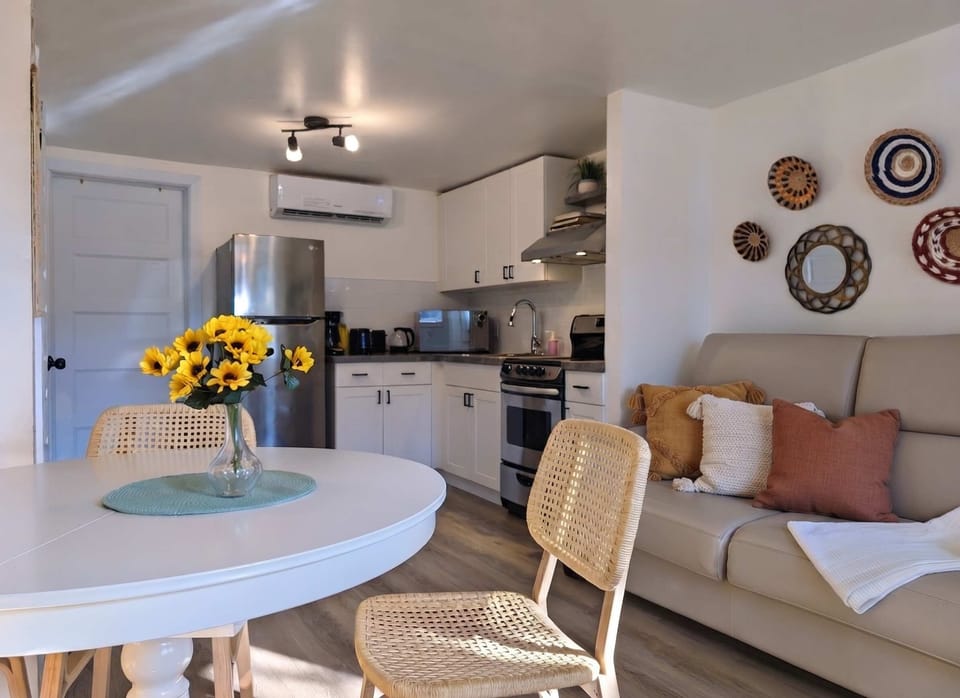 Espace de vie lumineux à aire ouverte avec une cuisine entièrement équipée, un salon confortable et une table à manger, idéal pour se détendre, partager un repas ou planifier votre prochaine escapade.