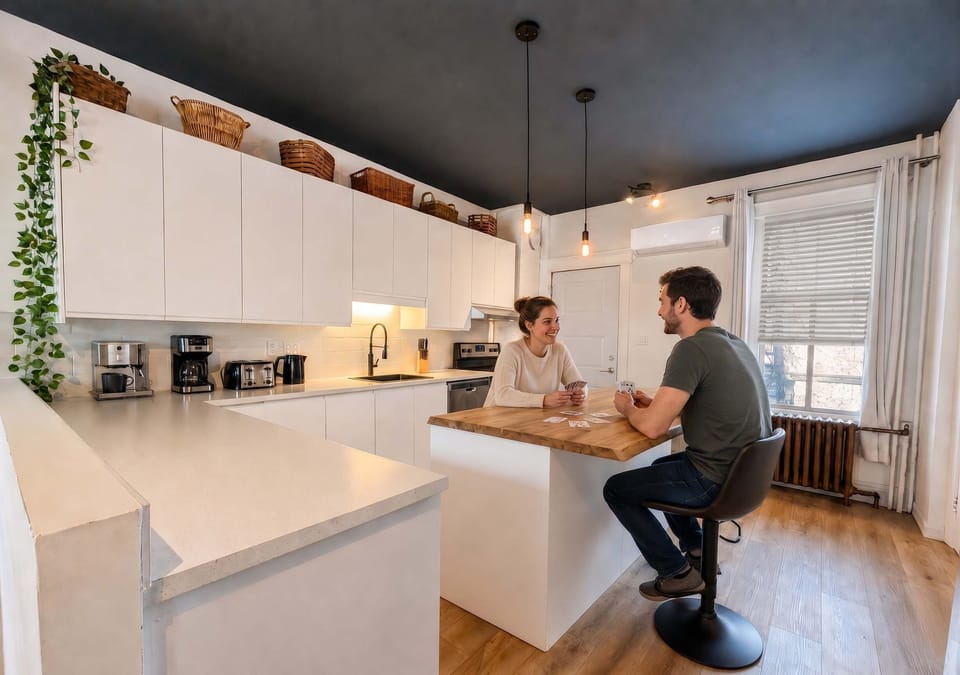 Cuisine lumineuse à aire ouverte dotée d'un îlot avec comptoir en bois, de tabourets modernes et d'un design minimaliste épuré.