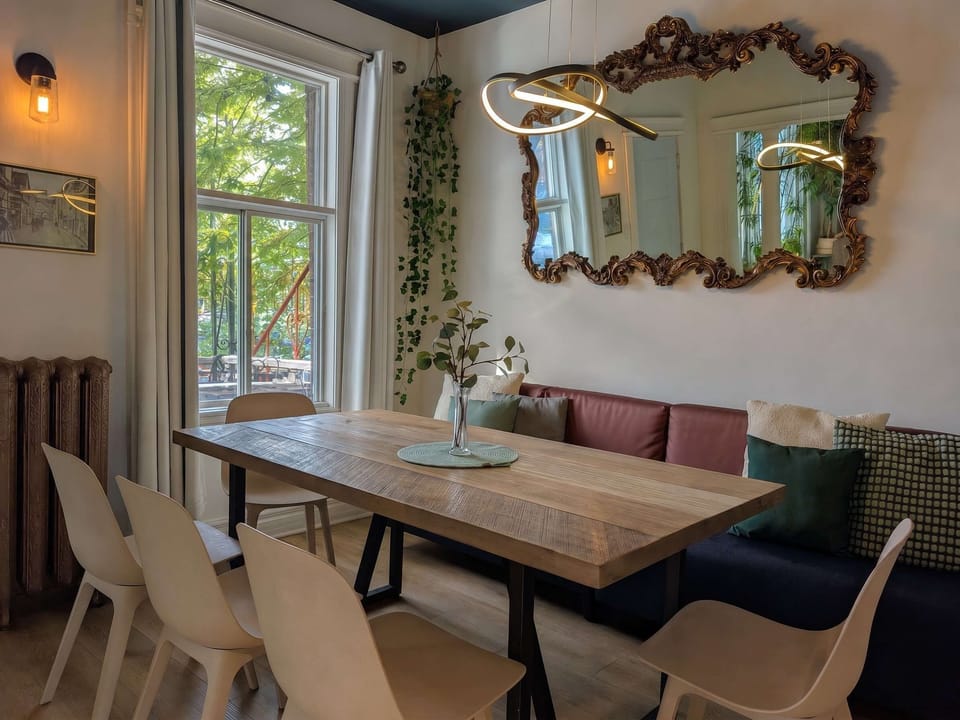 Rassemblez tout le monde ! Cet espace repas spacieux comprend une grande table en bois rustique, des chaises modernes et confortables, ainsi qu'une banquette intégrée, idéale pour les repas en famille ou les soirées de jeux.