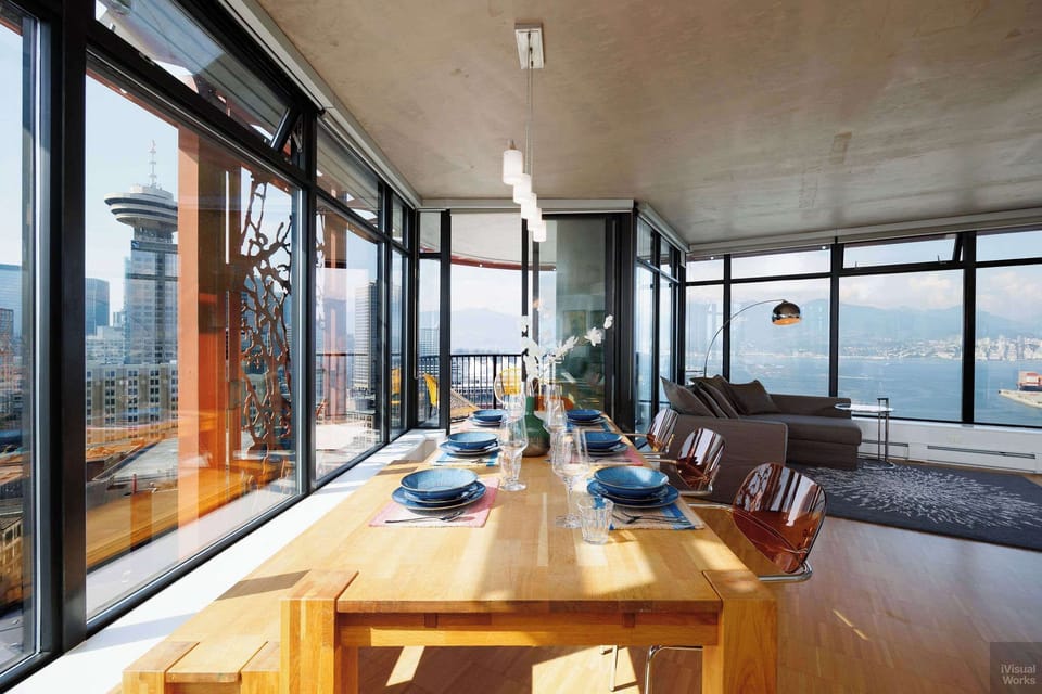 Welcome to a truly open-concept living space. The dining and living areas flow seamlessly together, with a continuous wall of windows providing a spectacular panoramic view of the city and water from every corner.