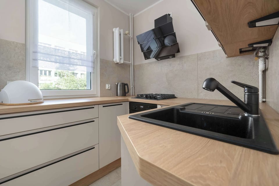 The kitchen's sleek design includes all necessary cookware and utensils.