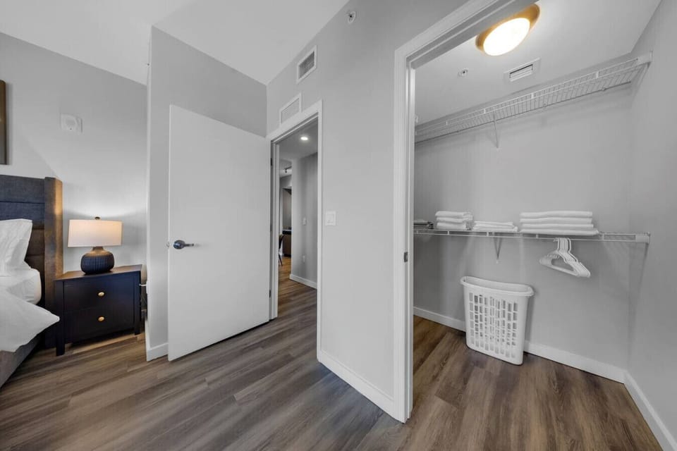 Bedroom with Walk-In Closet-Spacious bedroom with direct access to a walk-in closet featuring shelving, hangers, and fresh linens. Perfect for extended stays with ample storage space.