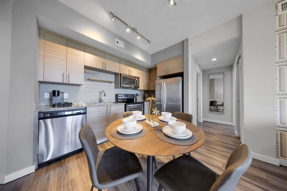 Contemporary Kitchen & Dining Area-Sleek kitchen with stainless steel appliances, ample cabinetry, and granite countertops. Round dining table set for four offers a cozy space for meals and gatherings.
