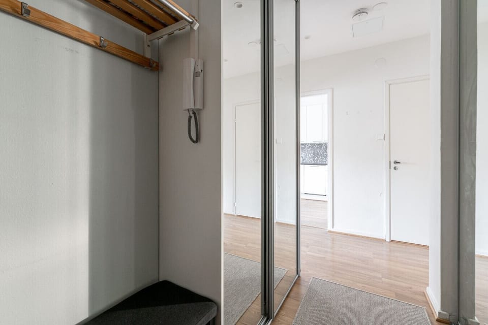Welcoming entrance with large mirrored closets and beautiful flooring.