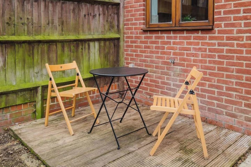 Enjoy the outdoor patio area, with a table and chairs, perfect for relaxing in the fresh air.