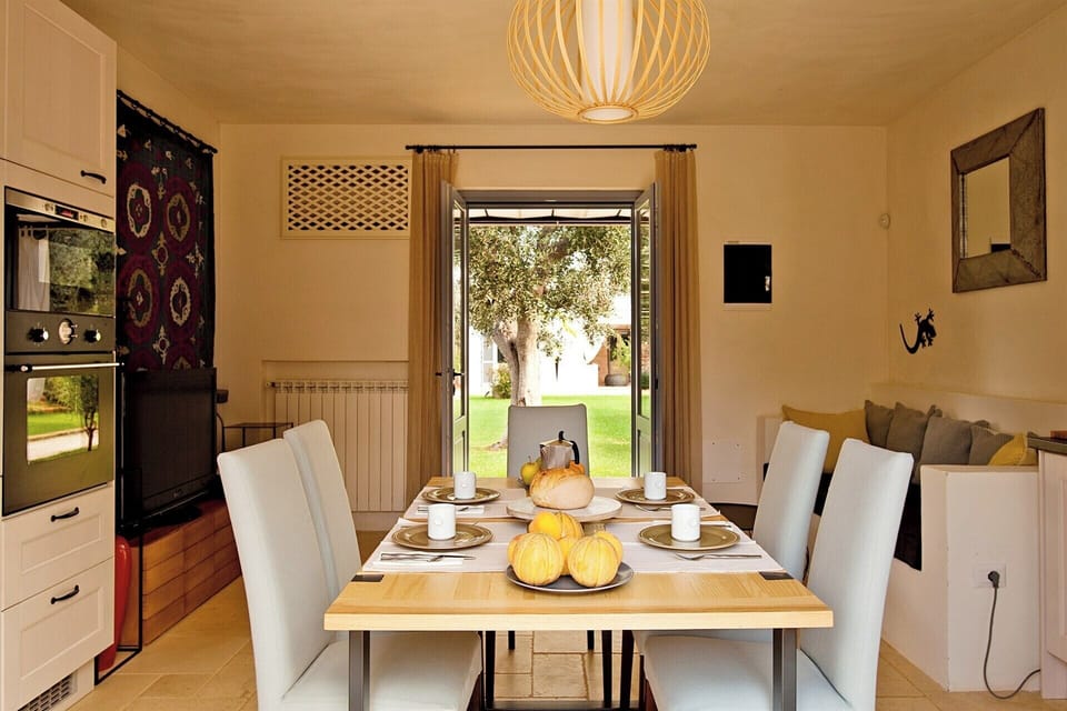 The large kitchen in the villa with its dining table and outdoor access.