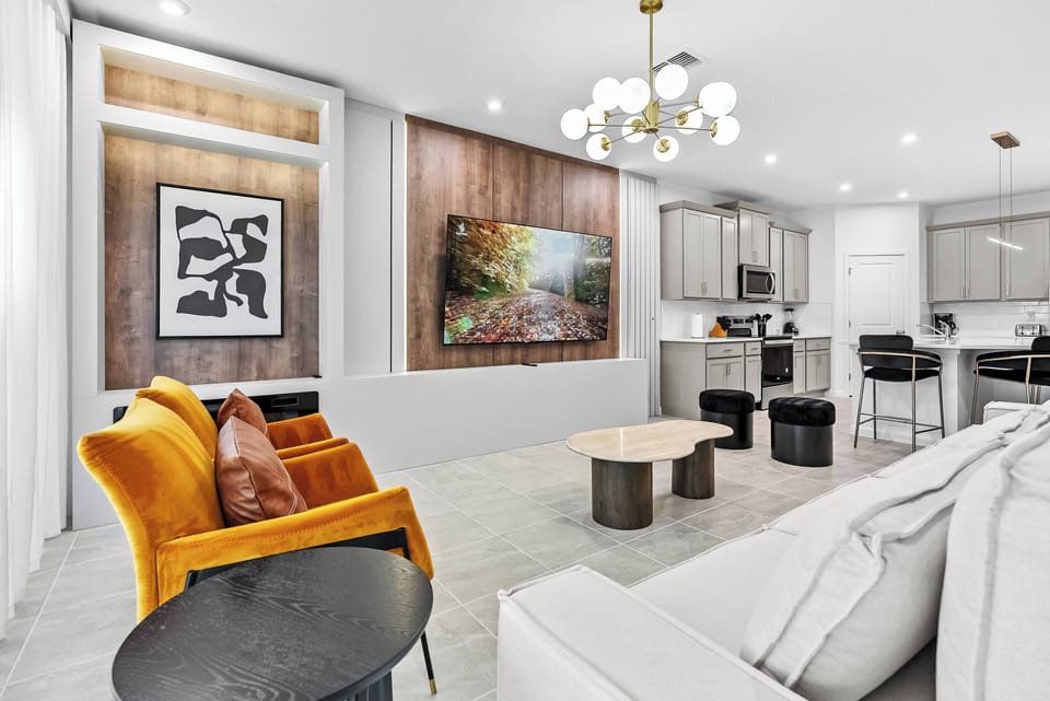 Unwind in this stylish living area, featuring bold yellow accent chairs and a textured wood panel backdrop. A chic coffee table enhances the modern vibe, while bright ambient lighting invites you to relax and feel at home.